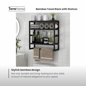 May include: Black bamboo towel rack with shelves, holding rolled towels, toiletries, and two hanging towels. The rack is mounted above a toilet. The text reads "Bamboo Towel Rack with Shelves" and "Stylish bamboo design".