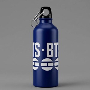 May include: A dark blue metal water bottle with a black screw-top lid and a silver carabiner clip. The bottle features white text that reads IS-BTS and a graphic design consisting of three white circles with horizontal lines.