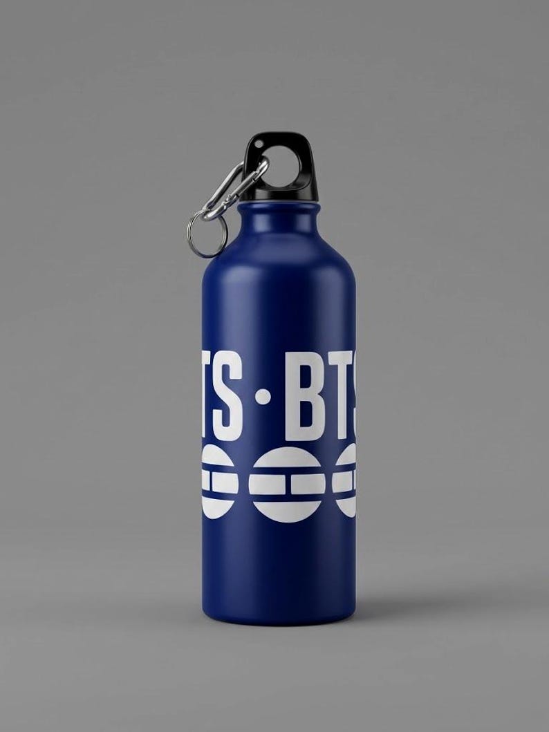May include: A dark blue metal water bottle with a black screw-top lid and a silver carabiner clip. The bottle features white text that reads IS-BTS and a graphic design consisting of three white circles with horizontal lines.