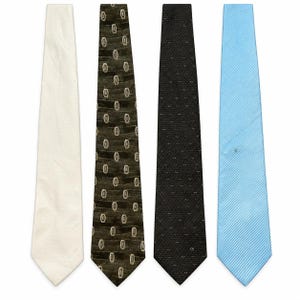 May include: A collection of four neckties arranged side by side. The first is solid off-white, the second is dark olive green with a repeating geometric pattern, the third is black with a subtle micro-dot texture, and the fourth is light blue.