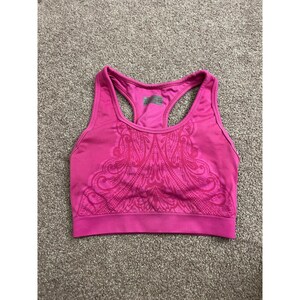 May include: A bright pink racerback sports bra featuring a tonal, intricate paisley-inspired pattern across the front chest area. The garment has a wide, ribbed elastic hem band and a scoop neckline, constructed from a smooth, flexible fabric.