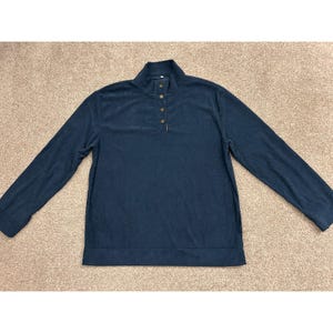 Op de afbeelding: Een donker marineblauw shirt met lange mouwen, voorzien van een opstaande kraag met een knoopsluiting met drie knopen. Het kledingstuk is gemaakt van een gestructureerde stof en heeft een rechte zoom en lange mouwen met eenvoudige boorden.