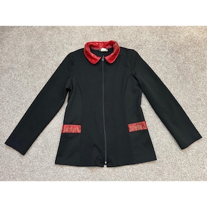 May include: A black long-sleeved jacket featuring a full-length front zip closure. The garment includes a contrasting red collar and two horizontal red pocket accents at the waist, providing a distinct colour block design on the solid black base.