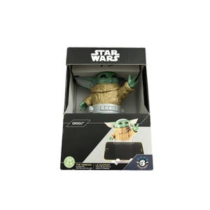 May include: A Grogu figure in a gold jacket is displayed in a Star Wars branded box. The box features the Star Wars logo and the name "GROGU". The figure is green with large ears and is holding up one hand.