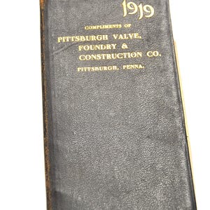 Könnte beinhalten: Ein Vintage-Broschüre in schwarzem Leder mit goldenen Buchstaben. Auf dem Einband steht "1919" und "Compliments of Pittsburgh Valve, Foundry & Construction Co., Pittsburgh, Penna."
