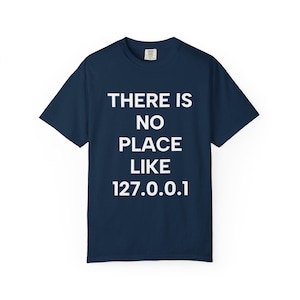 Könnte beinhalten: Marineblaues T-Shirt mit dem weißen Text "THERE IS NO PLACE LIKE 127.0.0.1". Das kurzärmelige Shirt besteht aus einem weichen Material und eignet sich für Freizeitkleidung.