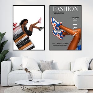 May include: Two framed art prints. One features a woman in a black dress and sneakers, leaning on a stack of books with designer names. The other shows legs wearing blue, white, and orange sneakers, with the text "FASHION" and "ART CREATES COLOR".