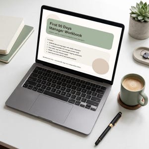 Può includere: Un computer portatile argentato mostra un documento digitale intitolato First 90 Days Manager Workbook con un'intestazione verde salvia e un elenco puntato. Lo schermo mostra testo su pagine di pianificazione e modelli di riunione.