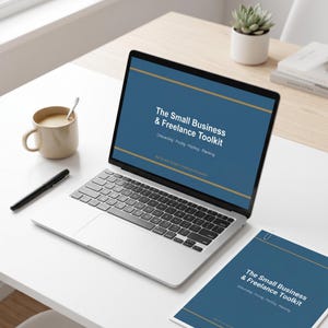 May include: A laptop displaying "The Small Business & Freelance Toolkit" text, with a matching document, a coffee mug, a pen, and a succulent plant. The laptop screen and document have a blue background with gold accents.
