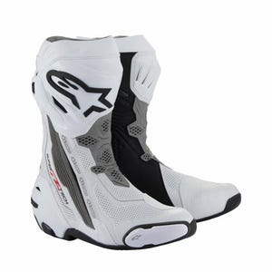 Puede incluir: Par de botas de moto blancas y negras. Las botas tienen un diseño de caña alta con un logotipo prominente en el lateral. Se ven detalles grises y perforaciones en el cuero blanco. Las botas están diseñadas para protección y rendimiento.