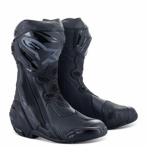 Puede incluir: Par de botas de moto negras. Las botas tienen un diseño aerodinámico con paneles reforzados y un logotipo prominente en la caña superior. Presentan una combinación de materiales lisos y texturizados, con detalles de malla para ventilación.