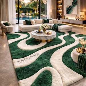 May include: A large, luxurious green and white area rug with a flowing, abstract design. The rug features a plush, textured pile and is the focal point of a modern living room. The rug's dimensions are not visible in the image.