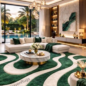 May include: A luxurious living room featuring a large, green and white patterned rug. A sectional sofa with green throw pillows and a matching blanket sits on the rug. A marble coffee table and a large window overlooking a pool complete the scene. The text "TuftHavenRugs" is visible.
