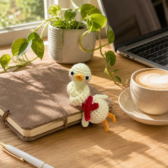 A crochet duck with an absurdly elongated neck — the kind of unhinged desk companion that makes coworkers stop and ask questions.