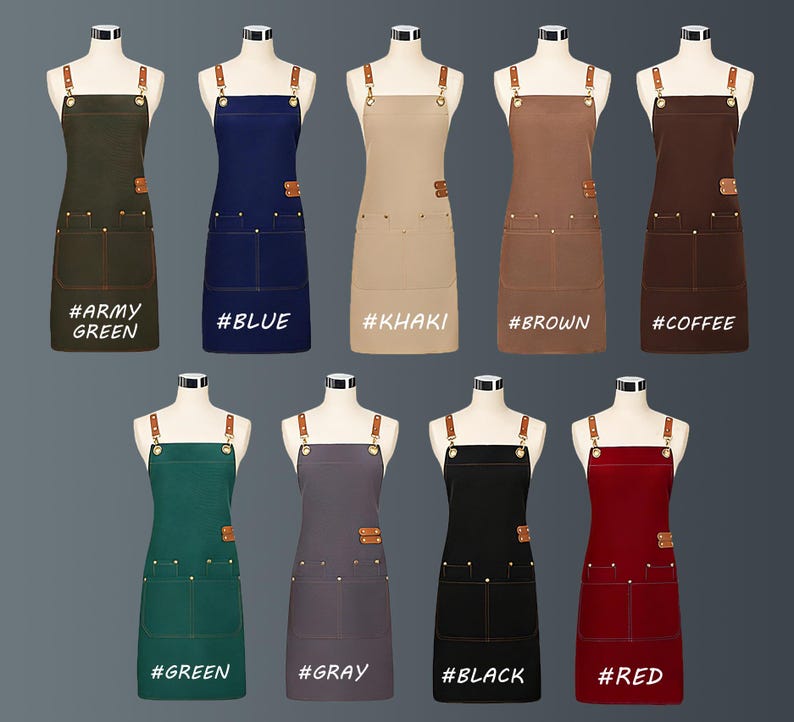 May include: A selection of aprons in shades such as army green, blue, khaki, brown, coffee, green, grey, black, and red. Each apron features a bib, two front pockets, and leather straps. The aprons are displayed on mannequins.