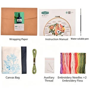 May include: An embroidery kit with various components. Includes a canvas bag with a floral design, embroidery floss in multiple colors, needles, a water-soluble pen, and an instruction manual. The kit is packaged in a brown wrapping paper.
