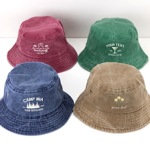 Könnte beinhalten: Ein Set aus drei Keramikbechern mit gesprenkelter, cremefarbener Glasur. Jeder Becher zeigt ein handgemaltes Blumendesign in Blau-, Grün- und Gelbtönen. Die Becher haben eine einfache, abgerundete Form und einen Griff.