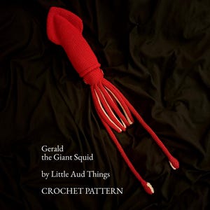 May include: A bright red crocheted squid toy with a long mantle and multiple tentacles featuring light-colored undersides. The text reads: Gerald the Giant Squid by Little Aud Things CROCHET PATTERN. The object is displayed against a dark background.