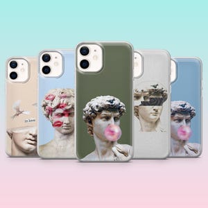May include: A collection of phone cases featuring classical sculpture designs. The cases display images of busts with bubblegum, lipstick marks, and other artistic elements. The cases are in various colors, including green, blue, and beige.