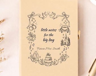 Può includere: Un taccuino beige chiaro con un bordo a linee nere raffigurante icone nuziali come colombe, anelli, un'auto, una chiesa e una torta. Il testo recita little notes for the big day e Future Mrs. Smith in un carattere corsivo e serif.