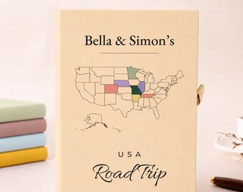 Può includere: Un diario color crema con il testo Bella & Simon's e USA Road Trip. La copertina mostra una mappa in nero degli Stati Uniti con alcuni stati evidenziati in verde, viola, rosa, verde scuro e giallo su uno sfondo di colore chiaro.