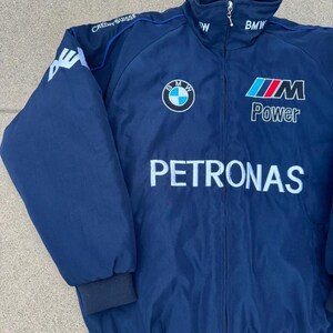 May include: Navy blue zip-up jacket with the BMW logo, "M Power", and "Petronas" text. The jacket has a stand-up collar, blue trim, and black cuffs and hem. The left sleeve has a white logo and the text "Credit Suisse".
