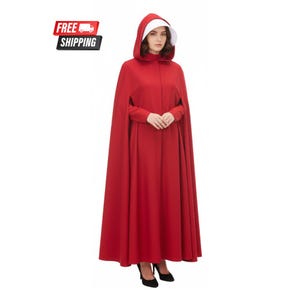 May include: A long, red cloak with a matching hood and a white bonnet. The cloak is floor-length and has long sleeves. The hood frames the face, and the bonnet is visible. The outfit is a solid, vibrant red color.