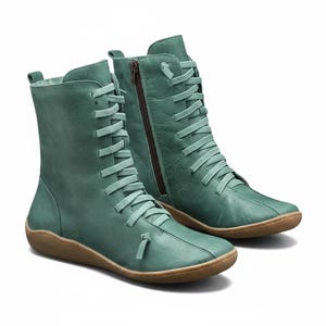 K&ouml;nnte beinhalten: Ein Paar tealfarbene kn&ouml;chelhohe Stiefel. Die Stiefel haben ein Schn&uuml;rdesign mit passenden tealfarbenen Schn&uuml;rsenkeln und einen seitlichen Rei&szlig;verschluss. Die Sohlen sind hellbraun.