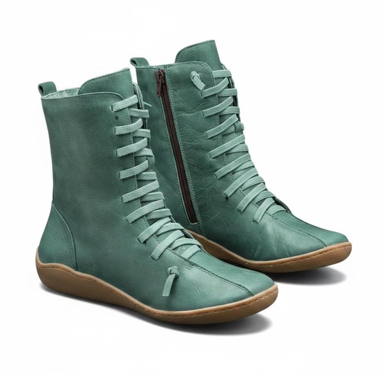 K&ouml;nnte beinhalten: Ein Paar tealfarbene kn&ouml;chelhohe Stiefel. Die Stiefel haben ein Schn&uuml;rdesign mit passenden tealfarbenen Schn&uuml;rsenkeln und einen seitlichen Rei&szlig;verschluss. Die Sohlen sind hellbraun.