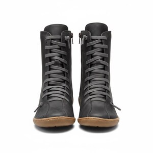 K&ouml;nnte beinhalten: Ein Paar dunkelgraue Lederstiefel mit grauen Schn&uuml;rsenkeln und einem seitlichen Rei&szlig;verschluss. Die Stiefel haben eine runde Spitze und eine braune Sohle. Die Stiefel sind kniehoch.