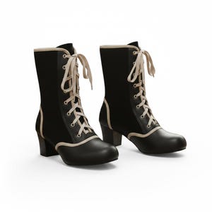 May include: A pair of black lace-up boots with a cream-colored trim and laces. The boots have a rounded toe and a block heel. The design is reminiscent of vintage or Victorian-era footwear.