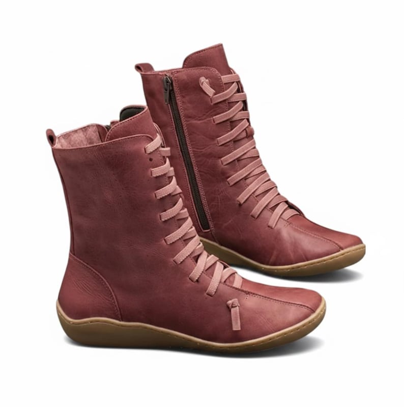 K&ouml;nnte beinhalten: Burgunderfarbene Stiefel mit Schn&uuml;rung und seitlichem Rei&szlig;verschluss. Die Stiefel haben eine runde Spitze und eine hellbraune Sohle. Die Schn&uuml;rsenkel und der Rei&szlig;verschluss sind in einem helleren Burgunderfarbton gehalten. Die Stiefel sind aus leder&auml;hnlichem Material.