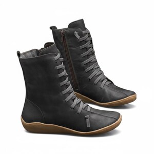 K&ouml;nnte beinhalten: Ein Paar schwarze kn&ouml;chelhohe Stiefel mit grauen Schn&uuml;rsenkeln und braunen Sohlen. Ein Stiefel hat einen seitlichen Rei&szlig;verschluss. Die Stiefel haben eine runde Spitze und ein l&auml;ssiges Design, das f&uuml;r den Alltag geeignet ist. Die Schn&uuml;rsenkel sind durch Metall&ouml;sen gef&auml;delt.