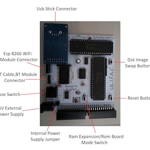 May include: A circuit board featuring a USB stick connector, Esp 8266 WiFi module connector, and UART cable/BT module connector. It includes a pause switch, 5V external power supply, and a reset button. The board is labelled "Ultimate Interface for Amstrad CPC".