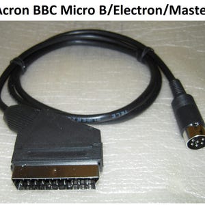 May include: A black cable with a SCART connector and a round 8-pin DIN connector. The cable is coiled and has the text "TELE" printed on it. The text "Acron BBC Micro B/Electron/Master" is at the top of the image.
