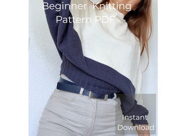 May include: A two-tone sweater with a white upper section and a navy blue lower section and sleeves. The text "Beginner Knitting Pattern PDF" and "Instant Download" are visible. The sweater is paired with light gray pants and a black belt.