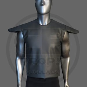 Puede incluir: Armadura de hombro negra, similar al cuero, con cuello redondo y hombreras extendidas. La armadura se exhibe en un maniquí. El texto "PROPS EUCBLACK" es visible en la armadura.