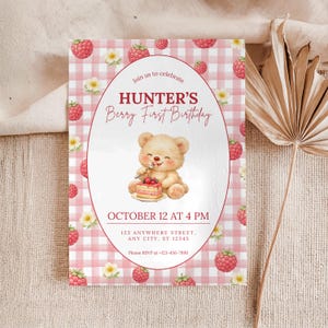 Puede incluir: Invitación de cumpleaños con fondo de cuadros vichy rosa y blanco. Destaca el texto "HUNTER'S Berry First Birthday", con un oso de peluche comiendo pastel. También se indica la fecha y hora de la fiesta.