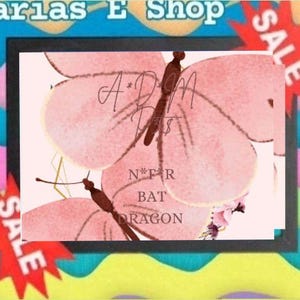 Könnte beinhalten: Ein rechteckiger gerahmter Druck mit zwei großen rosa Schmetterlingen mit braunen Körpern. Der Text A*D*M PETS und N*F*R BAT DRAGON ist in Schwarz über die Schmetterlinge gedruckt. Der Hintergrund ist hellrosa und rote Sternformen mit dem Wort SALE sind sichtbar.