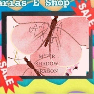 Könnte beinhalten: Ein rechteckiger schwarzer Rahmen mit einem hellrosa Hintergrund und zwei braunen Schmetterlingsillustrationen. Der Text A*D*M P*T$ und M*F*R SHADOW DRAGON ist in der Mitte aufgedruckt. Der Rahmen liegt vor einem wellenförmigen, bunten Hintergrund mit roten Sale-Sternen.