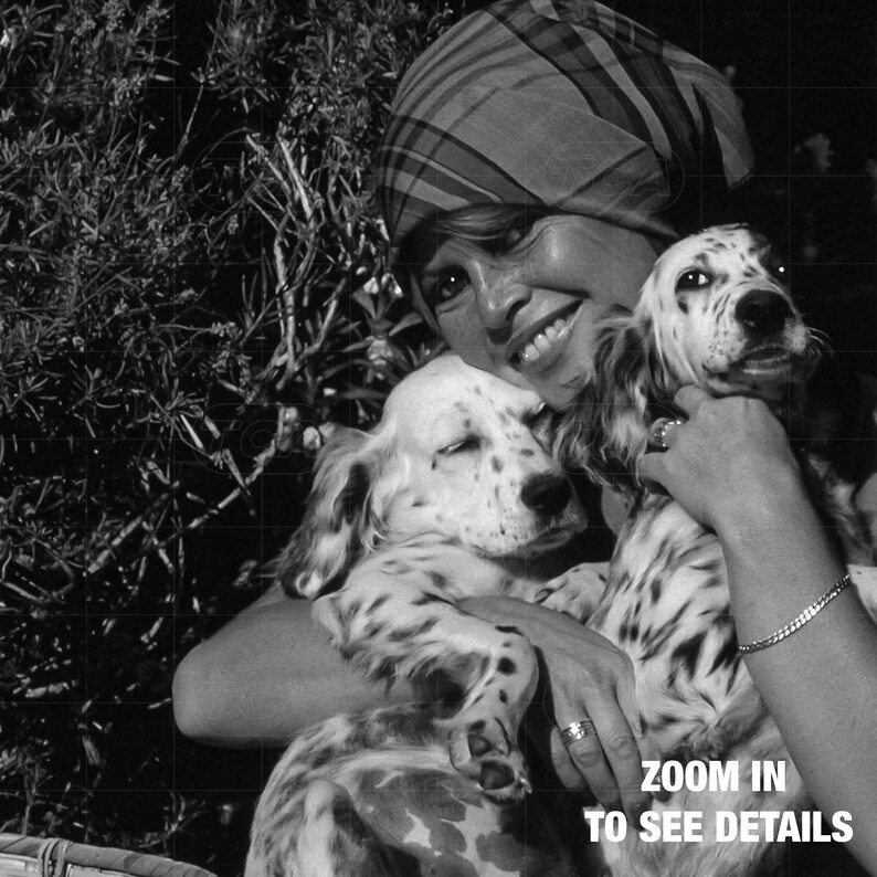 A woman is holding two dogs in her arms, smiling and embracing them.