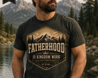 Könnte beinhalten: Ein anthrazitfarbenes T-Shirt mit einer sechseckigen Grafik, die eine Berglandschaft, eine Krone und den Text FATHERHOOD IS KINGDOM WORK, GUIDE LEAD PROVIDE PROTECT, EST. BY GOD zeigt. Das T-Shirt wird mit einer dunklen Baseballkappe und einer schwarzen Armbanduhr getragen.