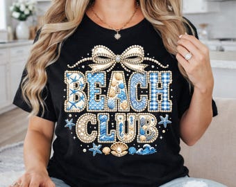 Könnte beinhalten: Schwarzes T-Shirt mit einem "BEACH CLUB"-Aufdruck. Das Design zeigt blau-weiße Muscheln, Seesterne und eine Schleife. Der Text ist in einer Mischung aus Schriftarten und Mustern, einschließlich Vichy und nautischen Elementen.
