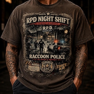 May include: Brown t-shirt with a distressed graphic featuring the text "RPD NIGHT SHIFT" and "RACCOON POLICE". The design includes a police car, figures, and the words "PROTECT & SURVIVE" and "TO SERVE & PROTECT".