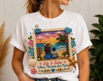 Könnte beinhalten: Ein weißes T-Shirt mit einem Grafikdruck eines Polaroid-Rahmens im Häkel-Stil. Das Bild zeigt eine Person und ein Kind, die bei Sonnenuntergang mit einer Palme am Strand sitzen. Der Text lautet, Life Is Better Where Memories Are Made.