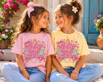 Könnte beinhalten: Zwei kurzärmelige T-Shirts, eines in Hellrosa und eines in Blassgelb, mit einem Grafikdruck aus einem Stern, rosa Schleifen und dem Text God is god all the time sowie Psalm 100:5. Die T-Shirts werden zu blauen Jeanshosen getragen.