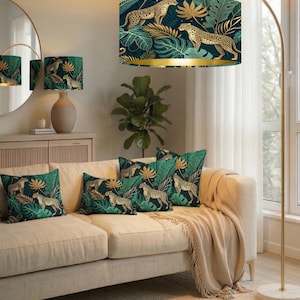 Può includere: Scena di soggiorno con lampada da terra e cuscini decorativi a tema giungla. Il paralume e i cuscini presentano un motivo di leopardi, foglie dorate e fogliame tropicale su sfondo blu scuro. Il divano è beige.