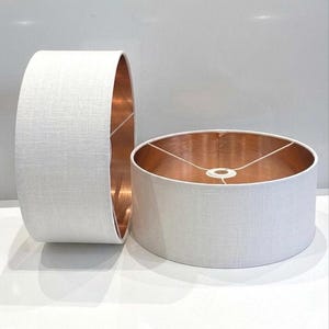 May include: A set of three ceramic mugs with a speckled, matte finish. The mugs are in shades of cream, light gray, and dark gray. Each mug has a simple, minimalist design, perfect for coffee or tea.