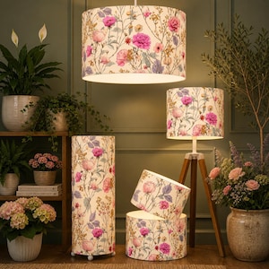 May include: A collection of floral lampshades in various sizes and styles. The shades feature a cream background with pink, purple, and yellow floral patterns. The lamps include a hanging pendant, a floor lamp, a table lamp, and two smaller shades.