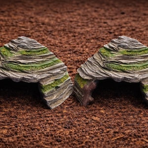 Könnte beinhalten: Ein Set aus drei Keramikbechern mit gesprenkelter, matter Oberfläche. Die Becher sind in Creme-, Hellgrau- und Dunkelgrautönen gehalten. Jeder Becher hat ein schlichtes, minimalistisches Design und einen abgerundeten Henkel.